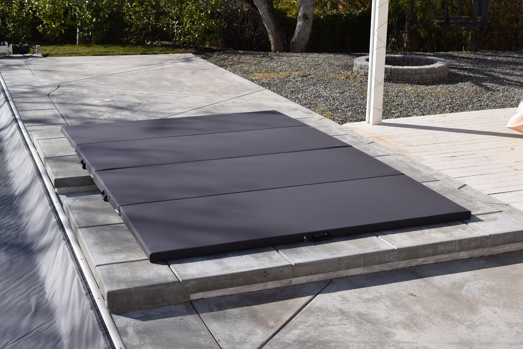 Four panel anthracite cover on a gunite spa with a spillway into the pool